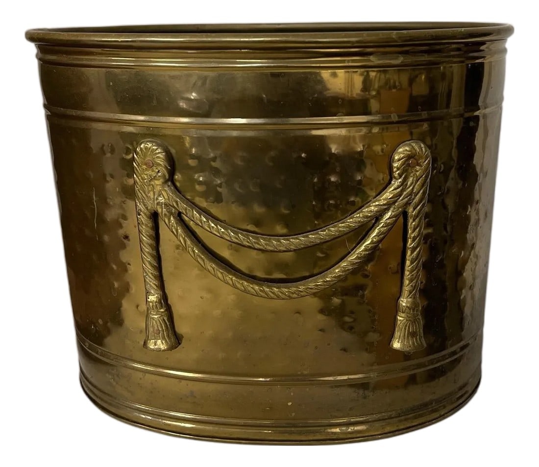 Vintage Hammered Brass Container, Planter, or Trash Can With Rope Design, India: Vintage hammered brass with rope swag embellishment on front. Would make a great wastebasket, container or planter. Measures 11" w x 8" d x 9" h. Light tarnish as expected with age. No holes or