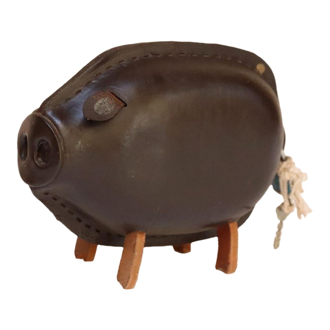 Mid-Century Modern Japanese Kounoike Leather and Brass Piggy Bank With Lock and Key: Charming Kounoike leather pig with slot on the side and a seam divide in the rear for storing and retrieving coins (ca. 1960s, Japan). Chocolate brown color with brass button eyes, leather ear flaps,