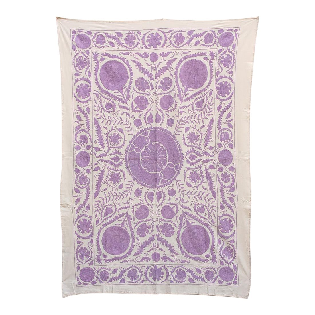 Lavender Pomegranate Hand-Embroidered Suzani Throw: This striking textile is an authentic Suzani (suzan is Persian for "needle"), hand-embroidered by women in Central Asia, traditionally as a significant piece of a bride's dowry. This specific piece is