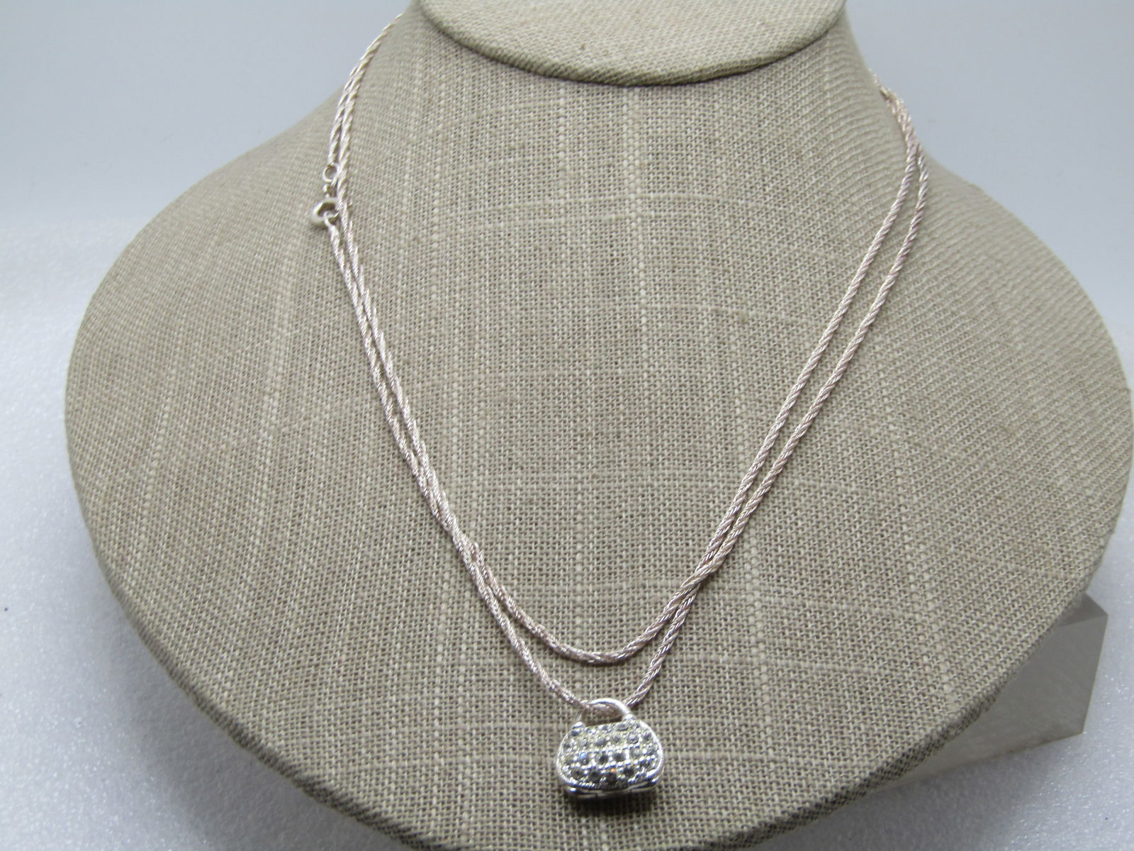 Vintage Sterling Rhinestone Purse Locket Necklace, Signed Jezlaine, 1980's-1990's, 36": Vintage Sterling Rhinestone Purse Locket Necklace, Signed Jezlaine, 1980's-1990's, 36". It has a rope chain, twisted design that is appx. 1.5mm wide with a petite 5/8" tall and wide purse that is hing