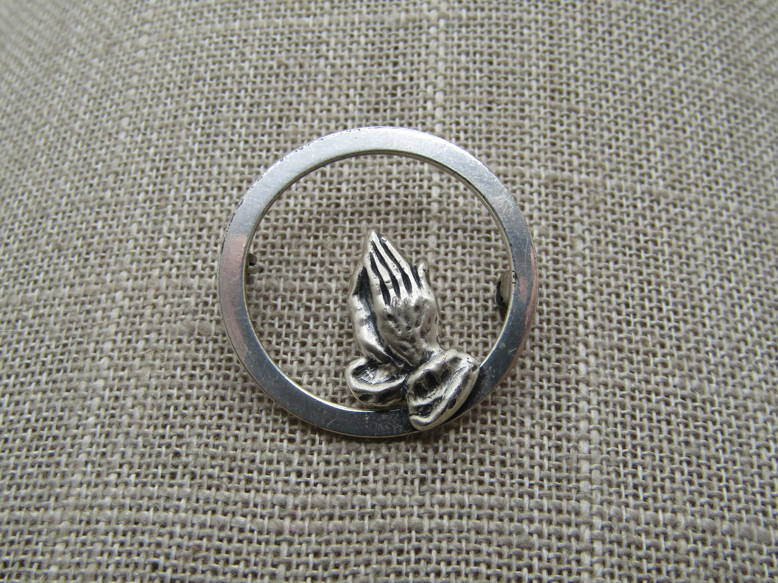 Vintage Sterling Praying Hands Circle Brooch, 1960's-1970's: Vintage Sterling Praying Hands Circle Brooch, 1960's-1970's and appx. 1-1/8" round. The praying hands are mounted on the bottom of the frame and are are mostly set inside the circle frame. It is