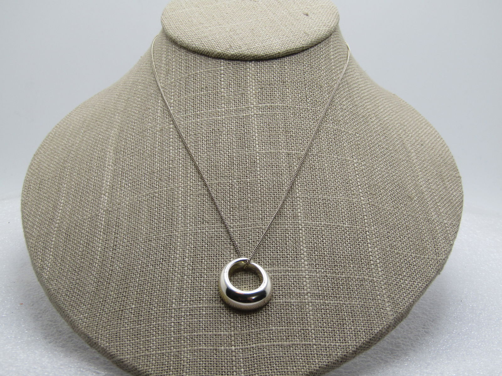 Sterling Tapered Oval Necklace, 16", 1990's: Sterling Tapered Oval Necklace, 16", 1990's. The pendant is a puffy oval on front, flat on bat that is appx. 3/4" tall and 5/8" wide. It is signed SU on the back and marked .925 and China. The chain i
