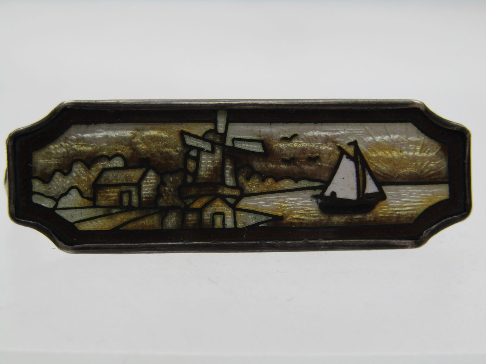 Vintage Sterling Dutch Scene Guilloche Brooch, 1920's-1930's: Vintage Sterling Dutch Scene Guilloche Brooch, 1920's-1930's. Rectangular sterling silver base with cut/curved corners and a white/yellow/brown/ black guilloche scene with windmill, cotage, trees,