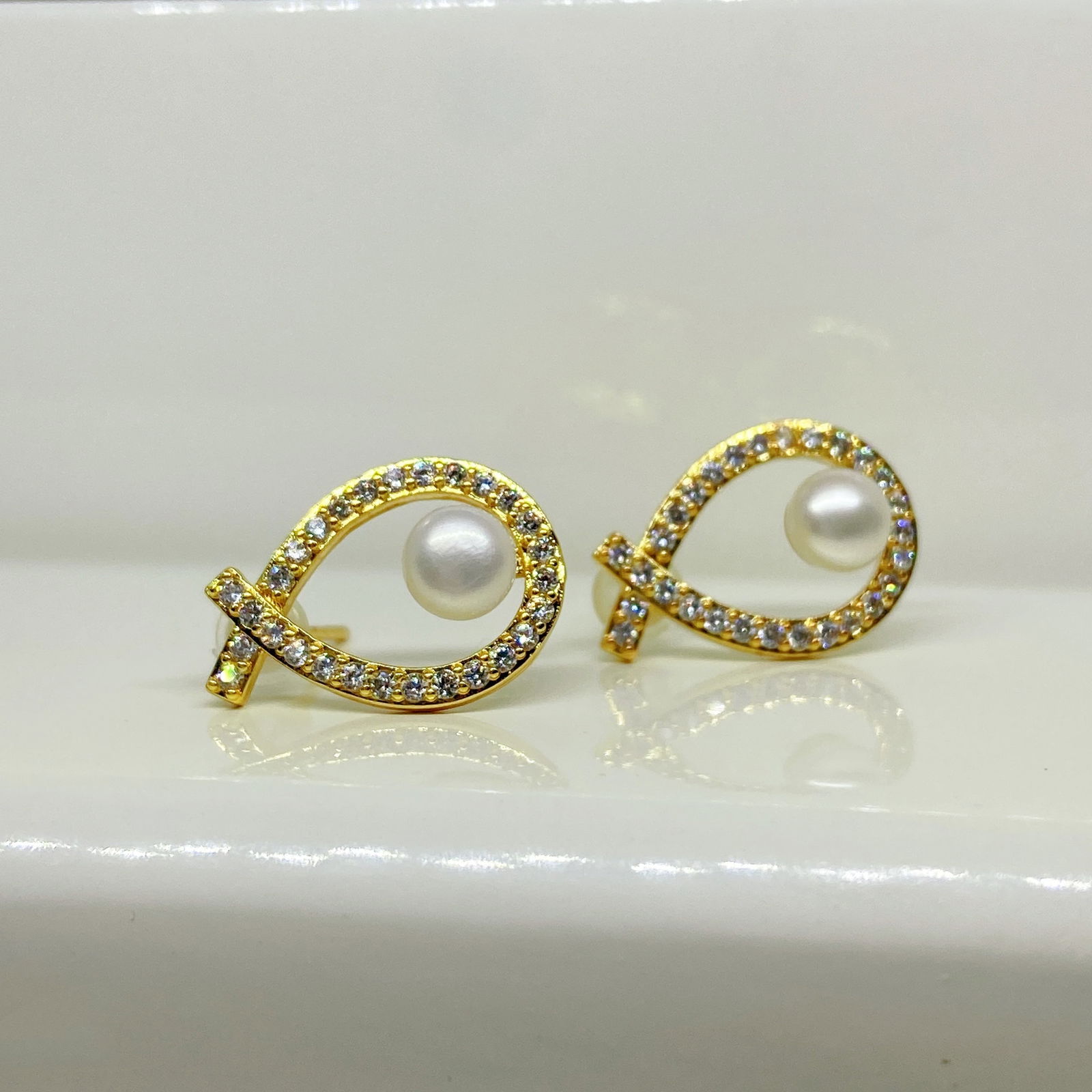 Freshwater cultured pearls Christian fish designed earrings: Title:Freshwater cultured pearls Christian fish designed earringsDescription:Freshwater cultured pearls Christian fish designed earrings The earrings are made of 18k gold plated silver inlaid with