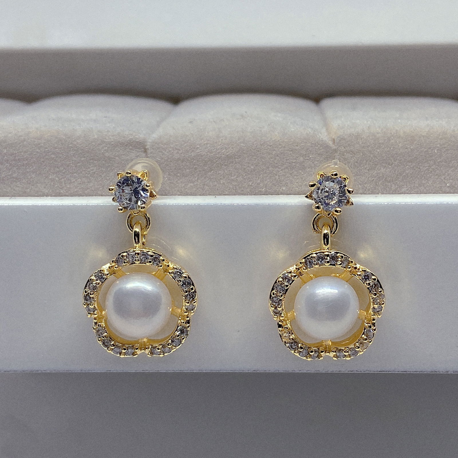 Cultured Pearls Flower Designed Earrings: Title:Cultured Pearls Flower Designed EarringsDescription:Cultured Pearls Flower Designed Earrings The earrings are made of 18k gold plated silver inlaid with light blue Moissanite and genuine