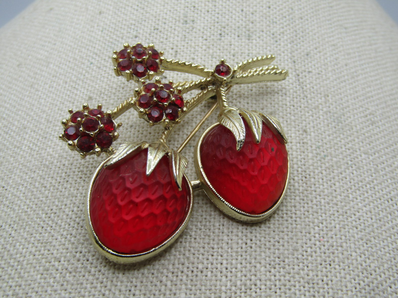 Vintage Strawberries & Rhinestones Brooch, Sarah Coventry, 1960's-1970: Vintage Strawberries & Rhinestones Brooch, Sarah Coventry, 1960's-1970. Gold tone with tree twisted stems with three dark red rhinestones blossoms and a single stone at the meeting of the stems fromw