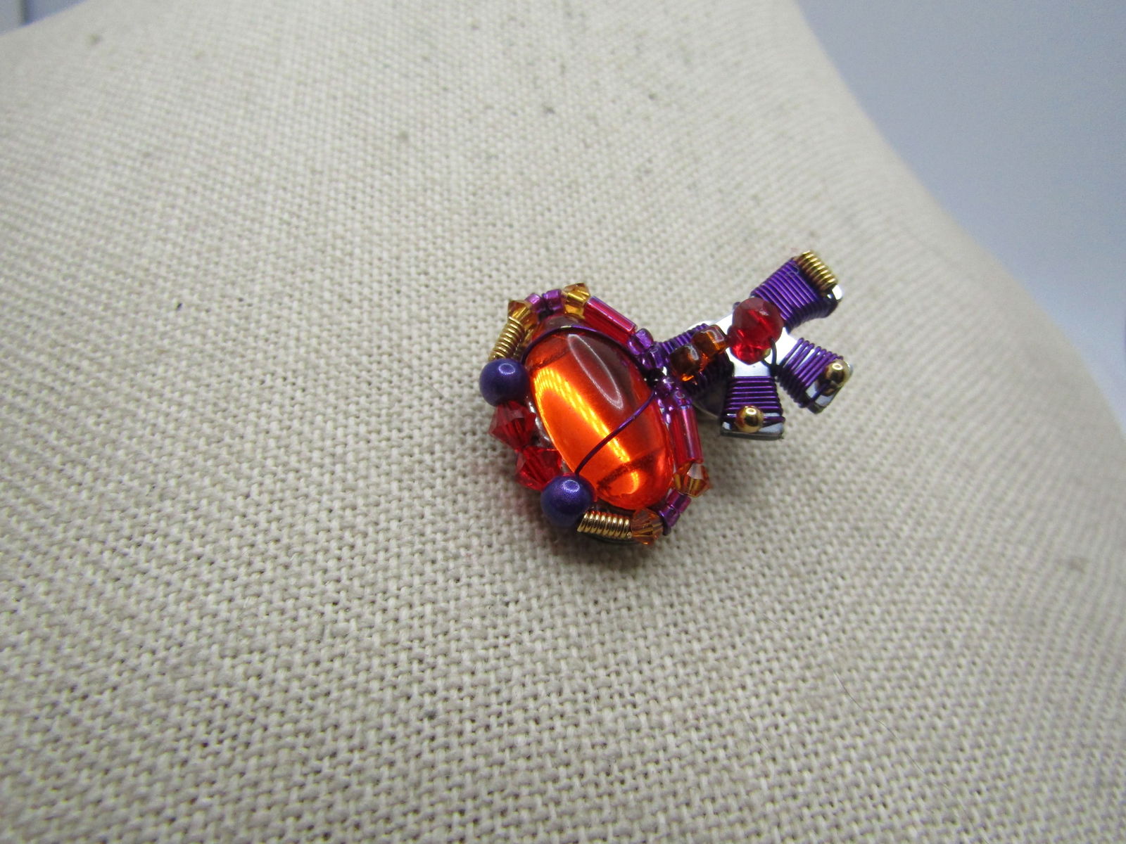 Liztech Mod Key Tack Pin, Orange/Purple/Red: Liztech Mod Key Tack Pin, Orange/Purple/Red. this has purpled wrapped thread with a large orange cabochon, purple iridescent beads and red beads. It is appx. 1.25" by 1" - Unisex - great on a tie