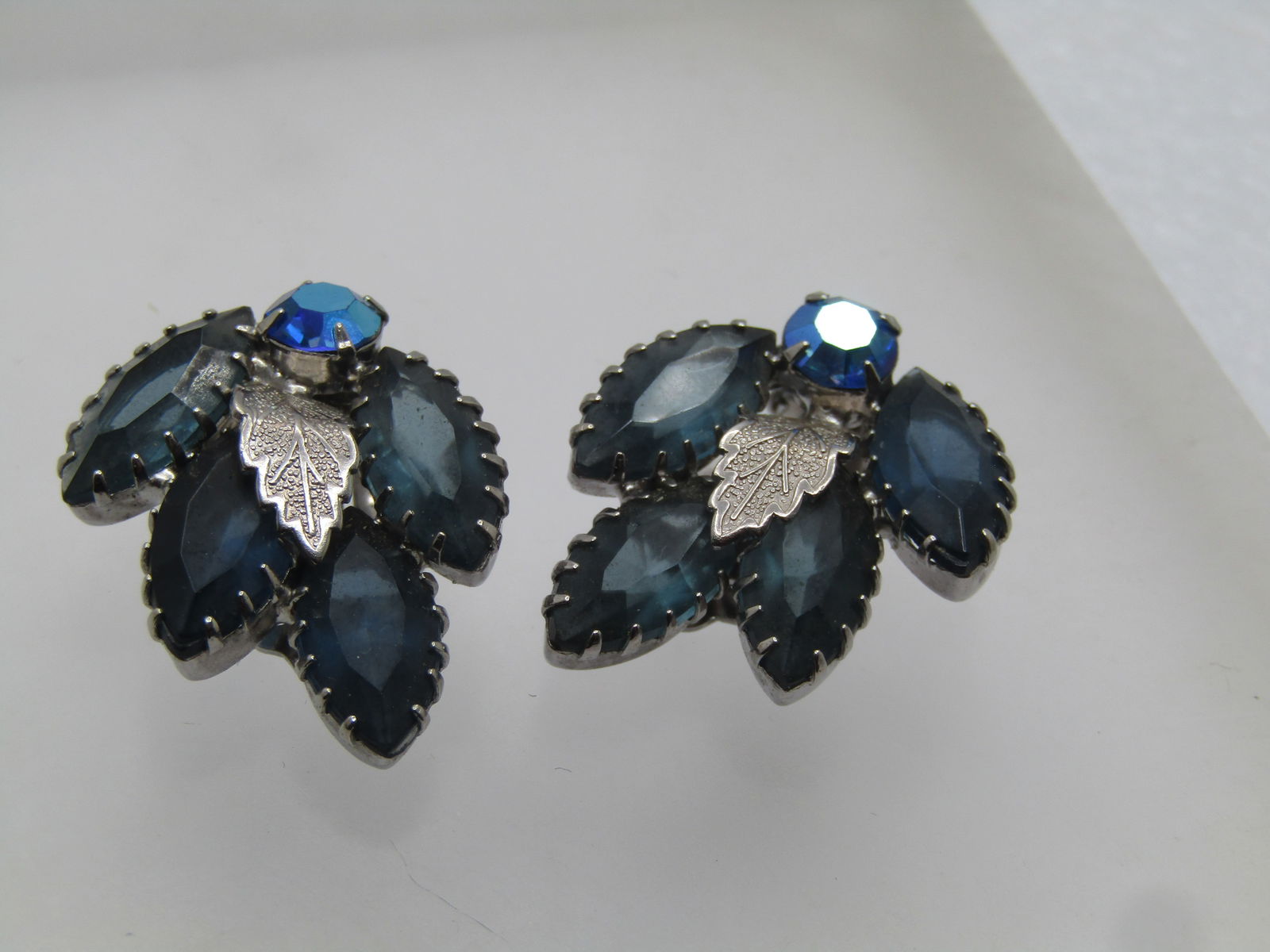Vintage Blue Rhinestone Leaf Clip Earrings, 1960's, Aurora Borealis: Vintage Blue Rhinestone Leaf Clip Earrings, 1960's, Aurora Borealis. Silver tone. This has four blue marquise rhinestones with many prongs holding the stones and a silver tone textured curved leaf