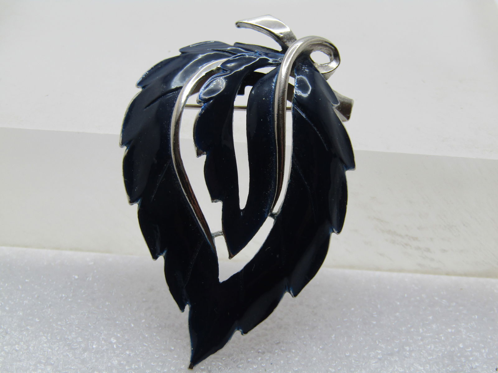 Vintage Dark Navy Leaf Brooch, 1960's-1970's: Vintage Dark Navy Leaf Brooch, 1960's-1970's. Silver tone with a domed and jagged leaf edges with silver tone stem and accents. It is appx. 2.25" tall and 1-1/3" wide. It has a solid silver tone