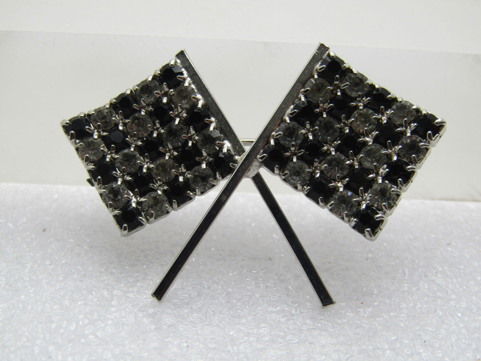 Vintage Rhinestone Checkered Flag Brooch, 1960's: Vintage Rhinestone Checkered Flag Brooch, 1960's. Crossed flags great to wear to a racing event. They brooch is silver tone with closed back settings and prongs on front holding the appx. 2.5mm