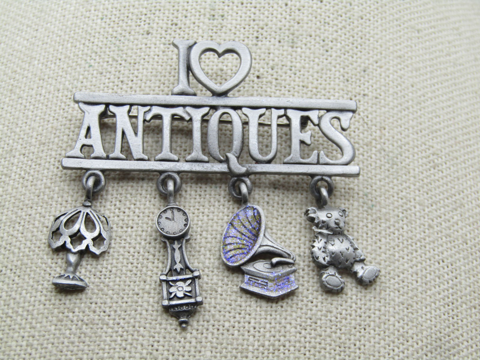 Vintage I Heart Antiques Brooch, Dangles, Signed JJ 1980's-1990's: Vintage I Heart Antiques Brooch, Dangles, Signed JJ 1980's-1990's. Pewter tone finish . The brooch is appx. 2" wide and slightly longer. It has dangling charm of item that an antique store would