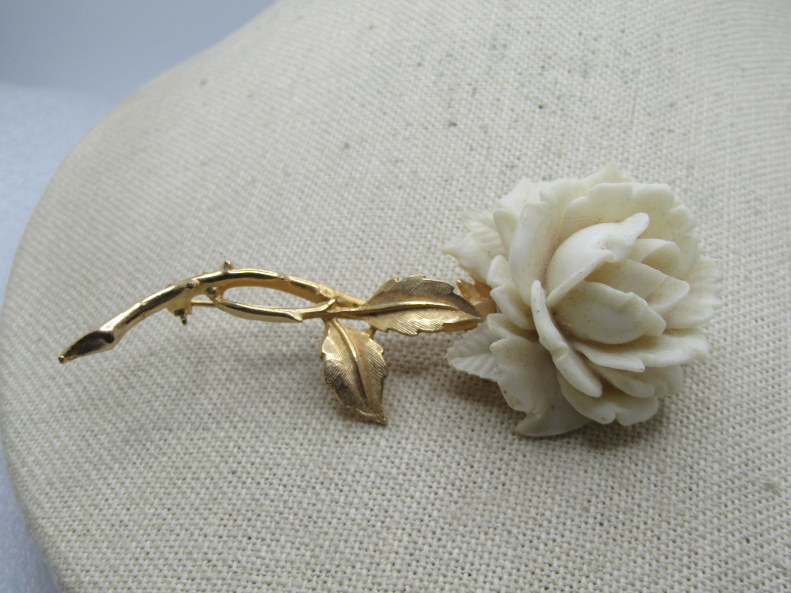 Vintage Faux Carved Rose Stem Brooch, Signed Accessocraft NYC, 1960's: Vintage Faux Carved Rose Stem Brooch, Signed Accessocraft NYC, 1960's. Faux carved 3-D rose blossom in a white lucite with a long gold tone stem with leaves. The brooch is appx. 3.5" tall and 1.5"