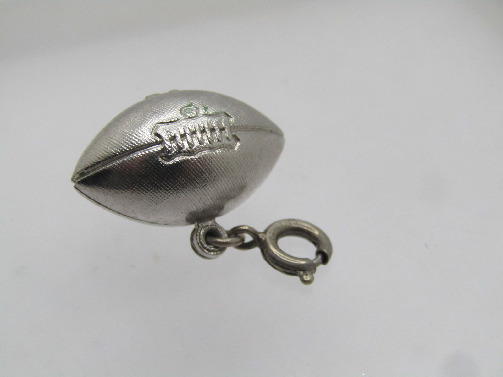 Vintage Monet Football Charm/Pendant, 1960's, Spring Ring: Vintage Monet Football Charm/Pendant, 1960's, Spring Ring. Silver tone textured football that is 1" wide and appx. 1-1/8" tall with the ring. The football is 3-D and appx. 13mm wide with textured