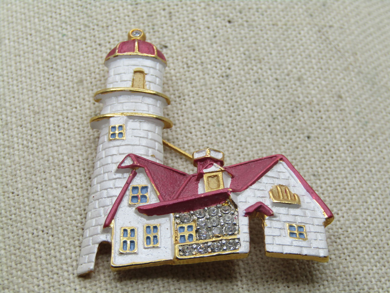 Vintage Enameled Lighthouse Brooch, Rhinestones, , 1980's-1990's: Vintage Enameled Lighthouse Brooch, Rhinestones, , 1980's-1990's. red and white enameled lighthouse with rhienstoens in the main windows and gold tone accents. It is appx.2" tall and 1.75" wide. 