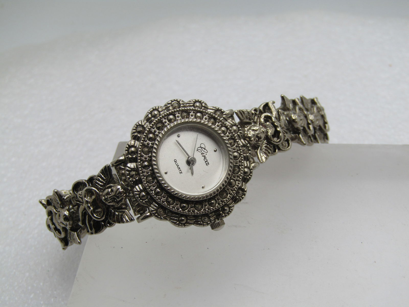 Circa Ladies' Wristwatch, Quartz, Angel Band, 1990's, 7.25": Circa Ladies' Wristwatch, Quartz, Angel Band, 1990's, 7.25". It has cute angels that are appx.1/2" wide in a bracelet style band with flip clasp. The watcher is a tired faux marcasite round design.