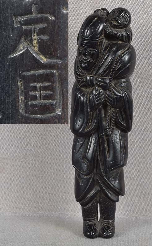 18/19c ebony netsuke FOREIGN MONKEY TRAINER by SADAKOKU 10.6cm: Late 18th to early 19th century good size kokutan (ebony) netsuke of a standing foreigner sarumawashi (traveling entertainer with trained monkey) wearing long robe and pants, holding a bamboo stick in