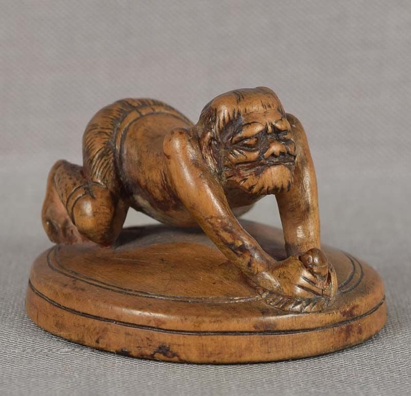 Early 19c netsuke ONI polishing mirror