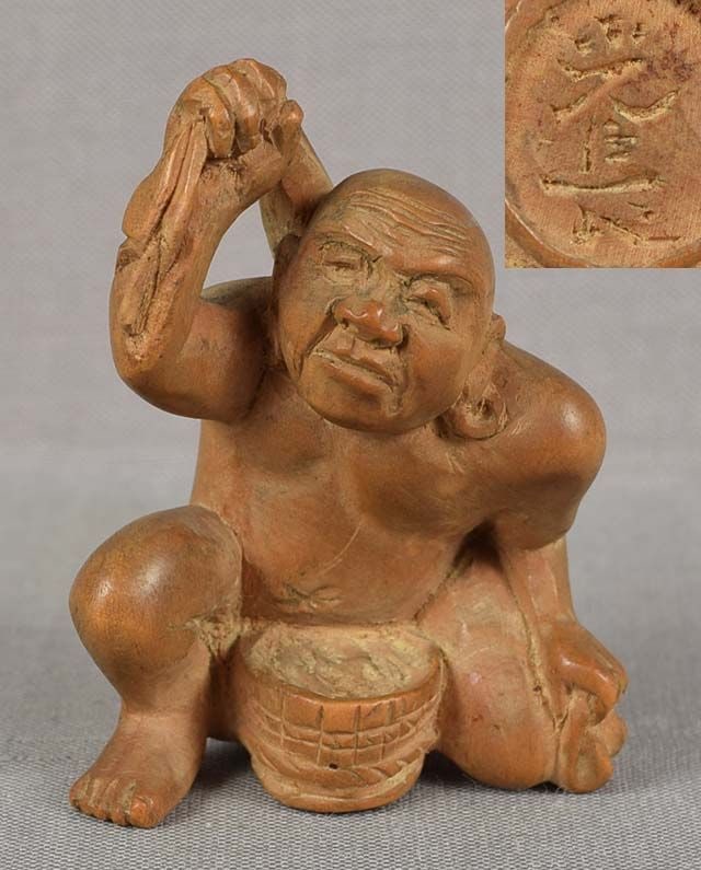 19c netsuke BATHING MAN with towel by MITSUNAGA: Late 19th century boxwood netsuke of a bathing man crouching before a wooden bucket and rubbing his back with a towel. Nicely carved, even grained unstained boxwood, nice face. Signed MITSUNAGA on