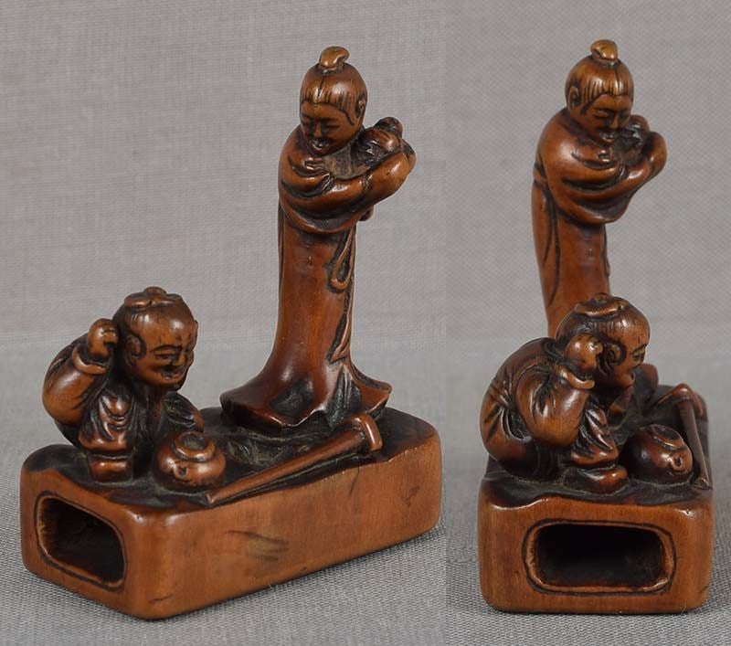 19c netsuke KAKKYO FAMILY & pot of gold: 19th century boxwood netsuke of a seated man, his hands raised in delight, a pot dug from a hole in the ground and a hoe in front of him, and a standing woman with a baby in her arms. The netsuke