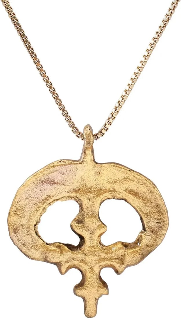 VIKING LUNAR PENDANT NECKLACE: Late 11th century. This gilted amulet combines a Viking icon, the moon, with the Christian cross. In the 11th century, Christianity made foot holds in Danelaw England, ruled by Vikings. A number of