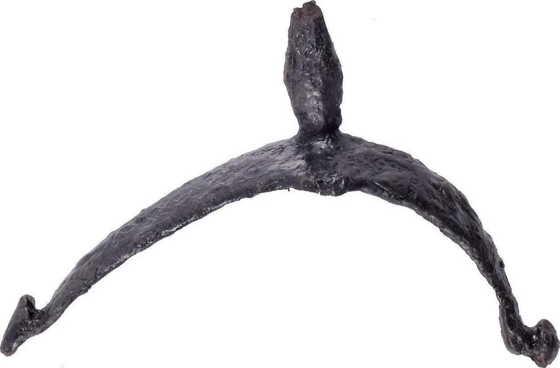 ROMAN LEGIONARIES IRON SPUR, C.100-350 AD: Finely forged and intricately formed with a ridged curved frame with one leg longer than the other. One tip with a stud to anchor the ankle strap and the other with a fastening hook. The frame