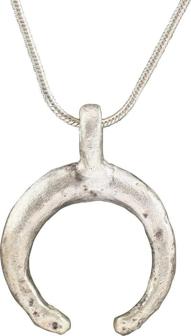 VIKING LUNAR PENDANT, C.850-1050 AD: Just 7/8" width. As expert navigators, the constellations signified mystery and power to Vikings. The Moon was personified as Mani, brother to Sol the Sun, and is abundantly represented in Norse