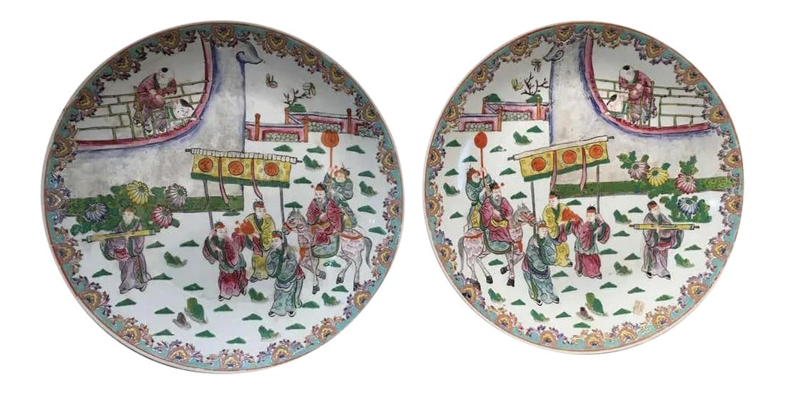 Famille Rose Chinese Porcelain Charger Platters - a Pair: Very rare to find a true pair of Famille rose porcelain chargers. Look closely, there is a left hand view and right hand view. Scene depicts an important arrival complete with entourage and onlookers.