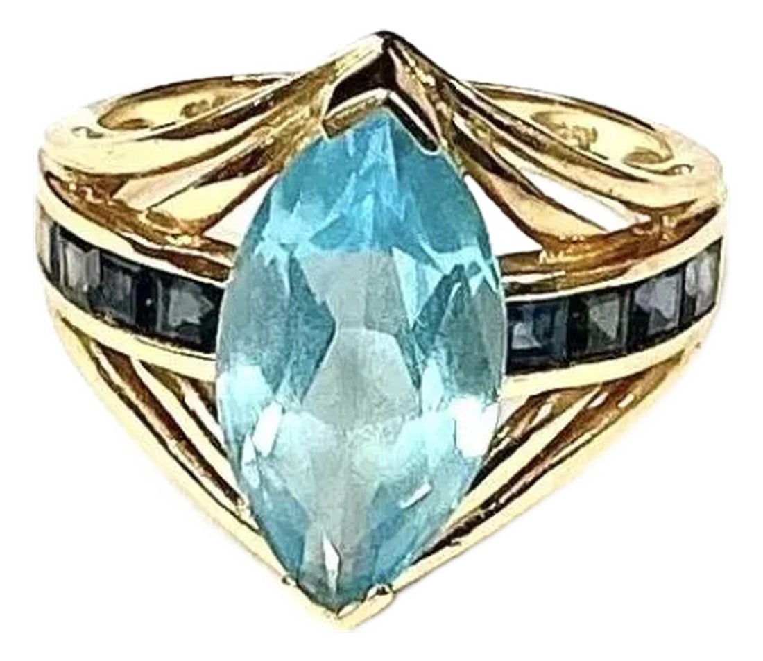 Light Blue Topaz With Dark Blue Topaz Baguettes 14k Yellow Gold Ring: 14k yellow gold marquise cut light blue topaz gemstone with dark blue topaz baguettes , 5.28 Grams TW. The dimensions are approximately 17 mm x 8.5 mm. Approximately 5 carats. Marked14k. Approximate