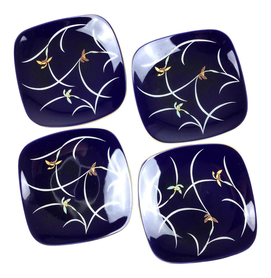 Vintage Set Trinket Plates Japan Porcelain: Gorgeous Cobalt Blue set of 4 plates. Each plate is decorated with a gold metallic rim and a simple organic floral design hand painted in soft flowing colors. Each plate is signed on the bottom 