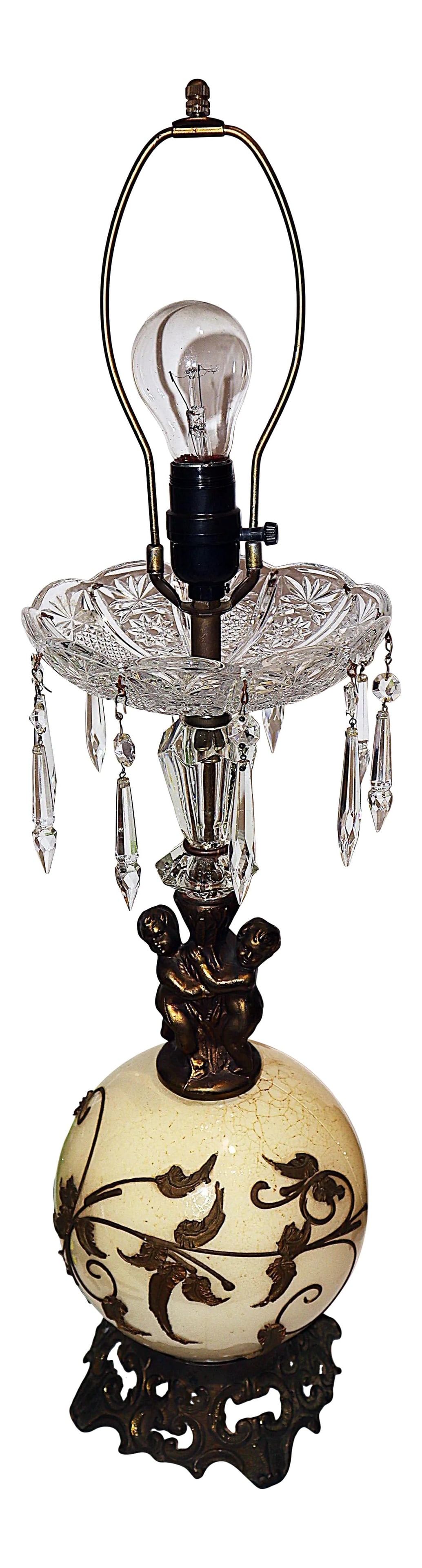 Hollywood Regency Crystal Cherub Table Lamp: Classic midcentury Hollywood Regency 1940s glass and crystal globe table lamp. Icicle prisms dangles from a poured crystal bowl and circle the cherub figurine who stands on a decorated glass globe.