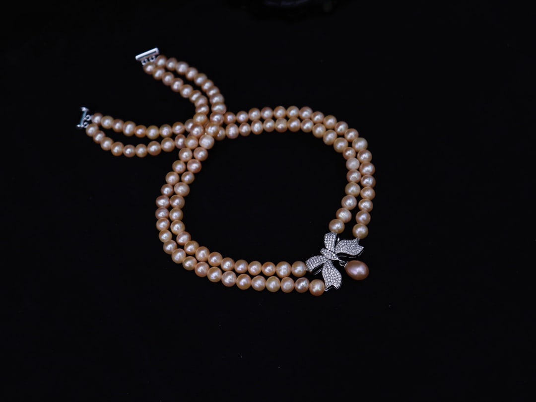 A natural pearl necklace with a bow: Title: A natural pearl necklace with a bow Description: A natural pearl necklace with a bow, the necklace is about 43cm long and weighs about 68 grams Reserve: $200.00 Shipping:Domestic: Shipping