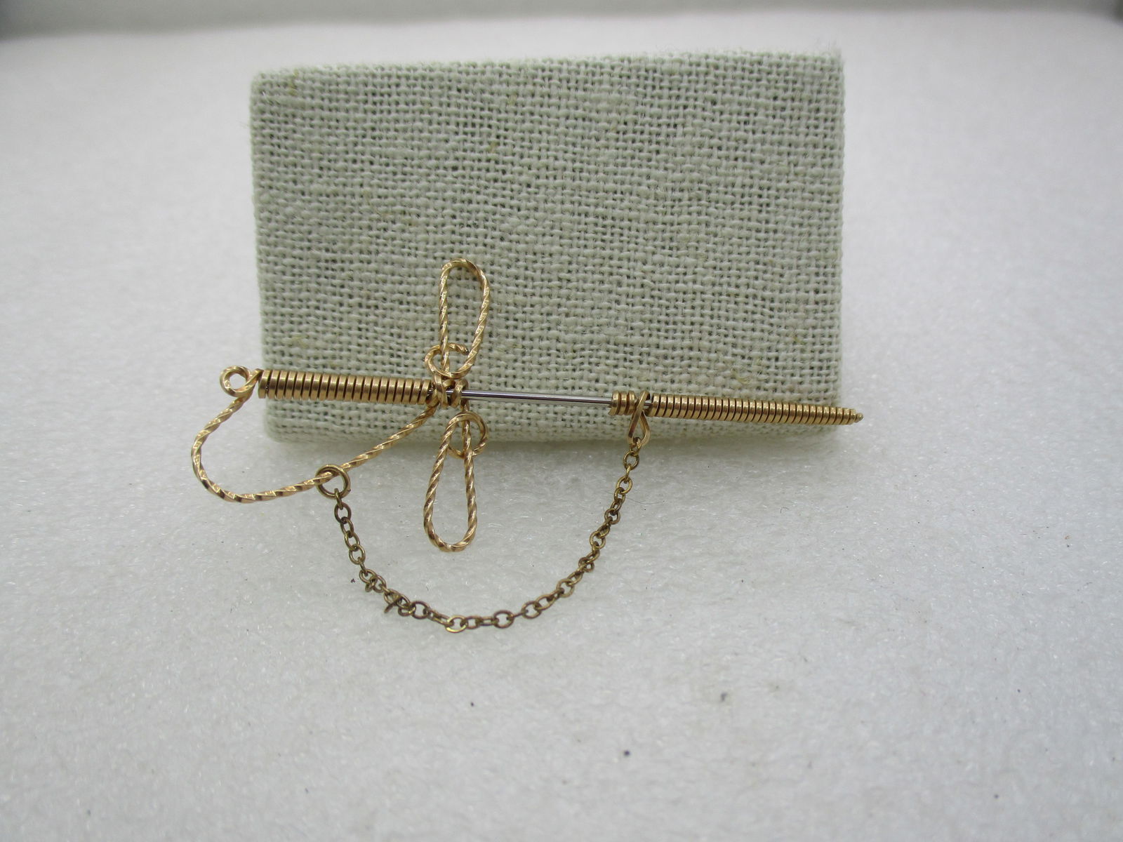 Vintage 10kt G.F. Hand Made Sword Stick PIn, Wrapped design.2.75": Vintage 10kt G.F. Hand Made Sword Brooch, Wrapped design.2.75" tall and 1.25" wide. Wrapped handle and scabbard. Loopedhilt . A chain links from the handle to the scabbard. Silver tone pin that slides