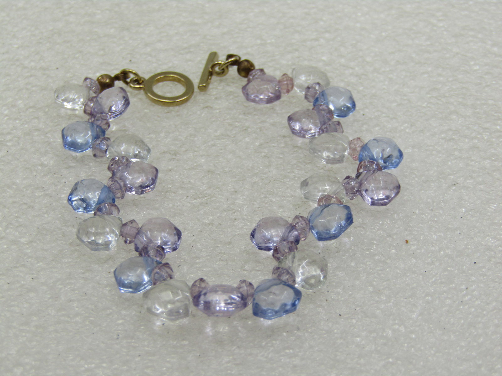 Early 1900's Heart Locket Necklace, 20" 12kt G.F.: Liz Claiborne Lavender/Blue Crystal Bracelet, 7" Toggle Clasp. The faceted beads are on both sides of the cord creating a wavy look and they look blue, lavender, and clear. Triangular faceted beads,