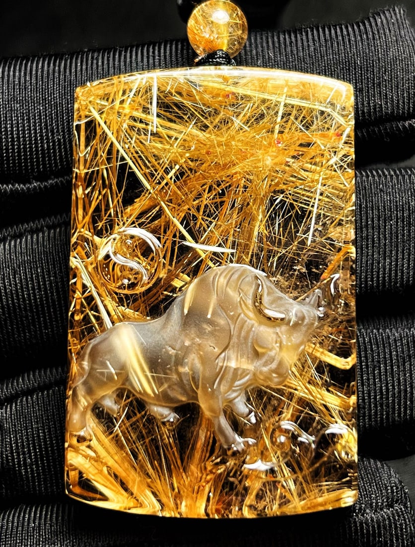 Natural Rutilated Quartz Carved Ox Pendant with Certificate: Title: Natural Rutilated Quartz Carved Ox Pendant with Certificate Origin: Chinese Date/Period: After2020 Materials: Rutilated Quartz Dimensions: 51x32x15(mm) 2.01x1.26x0.59(inches) Weight 0.12
