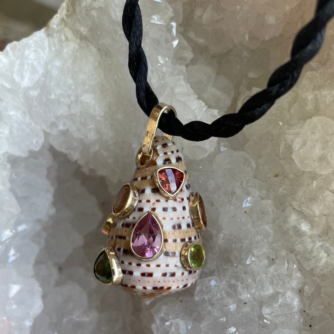 Conus Shell Pendant With Mixed Gemstones: Title:Conus Shell Pendant With Mixed GemstonesDescription:Conus Shell set with a variety of semi-precious stones all set in 14-Karat Gold. Stones include: Yellow and Pink Topaz, Swiss Blue Topaz,