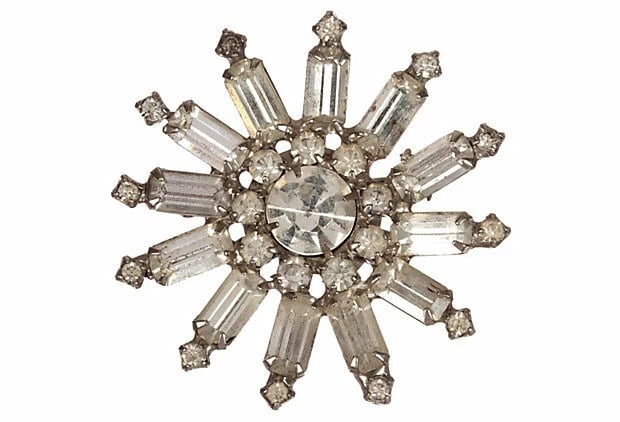 Starburst Rhinestone Pin: Title:Starburst Rhinestone PinDescription:1950s starburst pin with round and emerald cut clear rhinestones set in rhodium-plated costume metal. Round rhinestones, 3 mm Dia; 11 mm Dia. Emerald cut