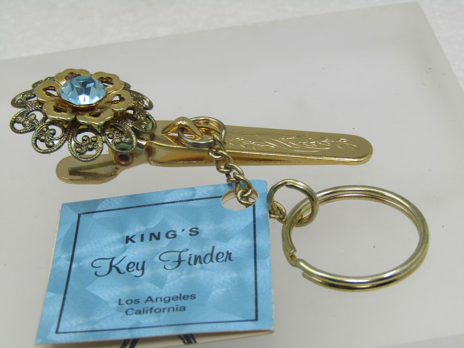 Vintage Blue Filigree Key Finder, King's , Unused, Original Card: Vintage Blue Filigree Key Finder, King's , Unused, Original Card. This is by King's of Los Angeles, CA and has the original card still attached. It has a key ring with a clip and gold tone filigree