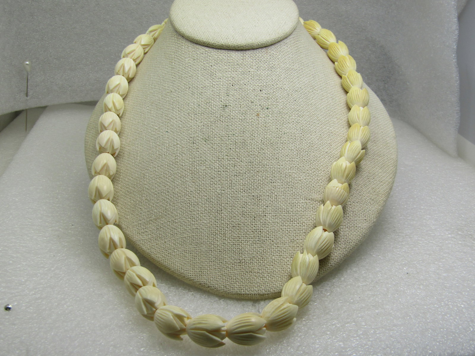 Vintage Faux Carved Tulip Blossom Necklace, 22": Vintage Faux Carved Tulip Blossom Necklace, 22". The clasp is a bead that has a twist closured. This is also strung on elastic cord so it has some give. The tulips are appx. 14mm long and 12mm