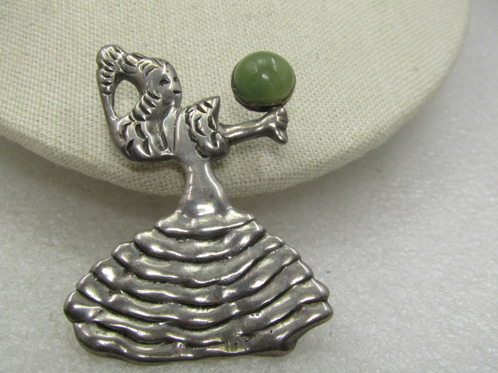 Vintage Mexican Flamenco Dancer with Green Quartz, 1940's-1950's, 2-5/8": Vintage Mexican Flamenco Dancer with Green Quartz, 1940's-1950's, 2-5/8" tall and 1-7/8" wide. It has a nearly 12mm round green quartz cabochon that is bezel-set in the right hand and what appears to
