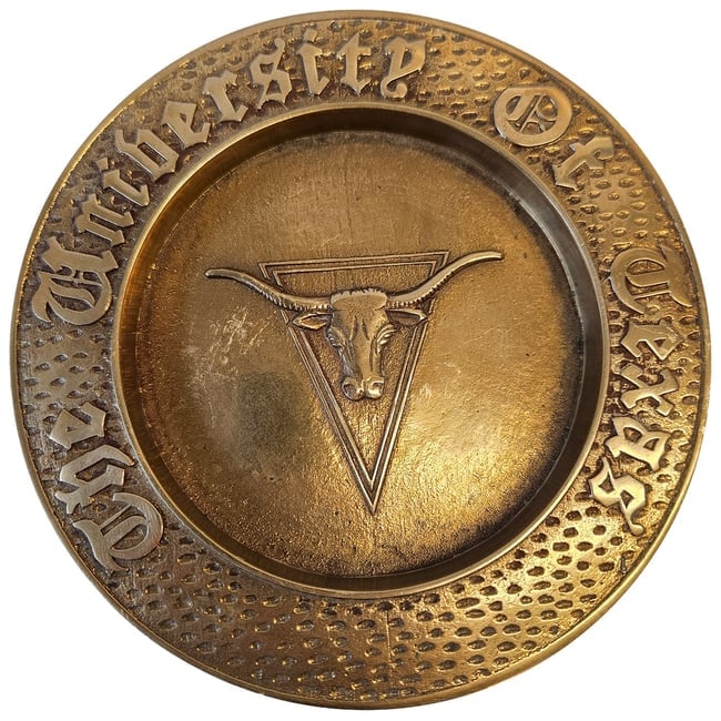 University of Texas Embossed Longhorn Brass Wall Hanging: Title: University of Texas Embossed Longhorn Brass Wall HangingDescription: Features a longhorn steer head encircled by the text "University of Texas" in a Gothic font overa hammered or dimpled textur