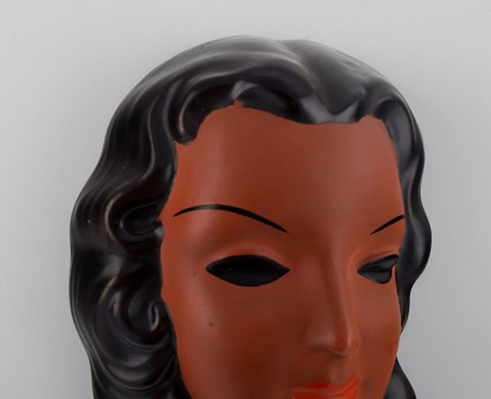 Goldscheider, Austria. Art deco female face in handpainted glazed ceramics. Dated 1953. - 2