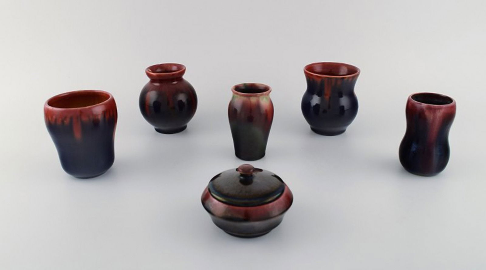 Michael Andersen, Bornholm. Five vases and a lidded jar in glazed ceramics. Beautiful glaze in red: Title: Michael Andersen, Bornholm. Five vases and a lidded jar in glazed ceramics. Beautiful glaze in red and dark shades. 1950's. Description: Michael Andersen, Bornholm. Five vases and a lidded jar