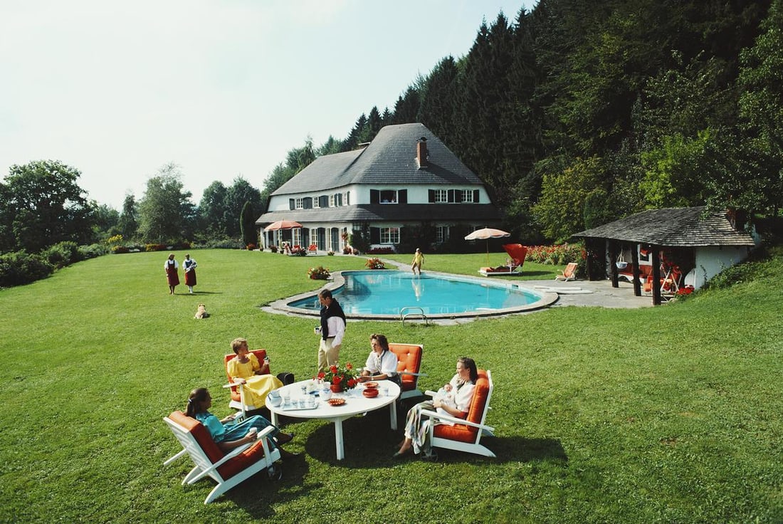 Slim Aarons Official Estate Print - Von Oswald House: 1986 (Printed later): Title: Slim Aarons Official Estate Print - Von Oswald House: 1986 (Printed later) Description: Von Oswald House A group of people relax in the garden at the house of Johanna Von Oswald, 1986. 60 x 40"