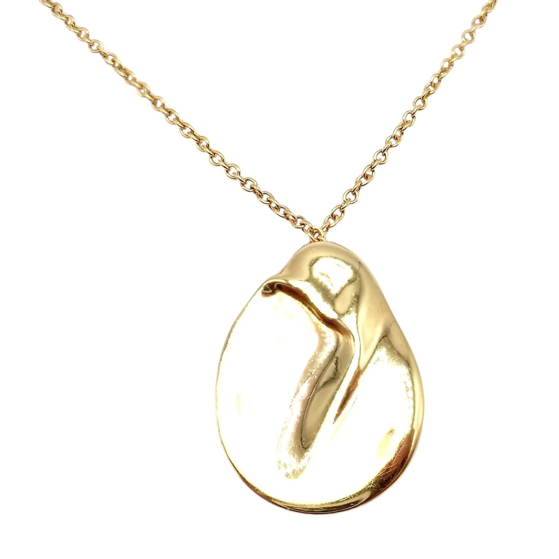 Tiffany & Co Peretti 18k Yellow Gold Madonna Medium Pendant Chain Necklace: This Tiffany & Co. Elsa Peretti 18k yellow gold Madonna pendant features her iconic sculptural design, symbolizing protection and serenity. Smooth, organic contours form a modern, minimalist silhouett
