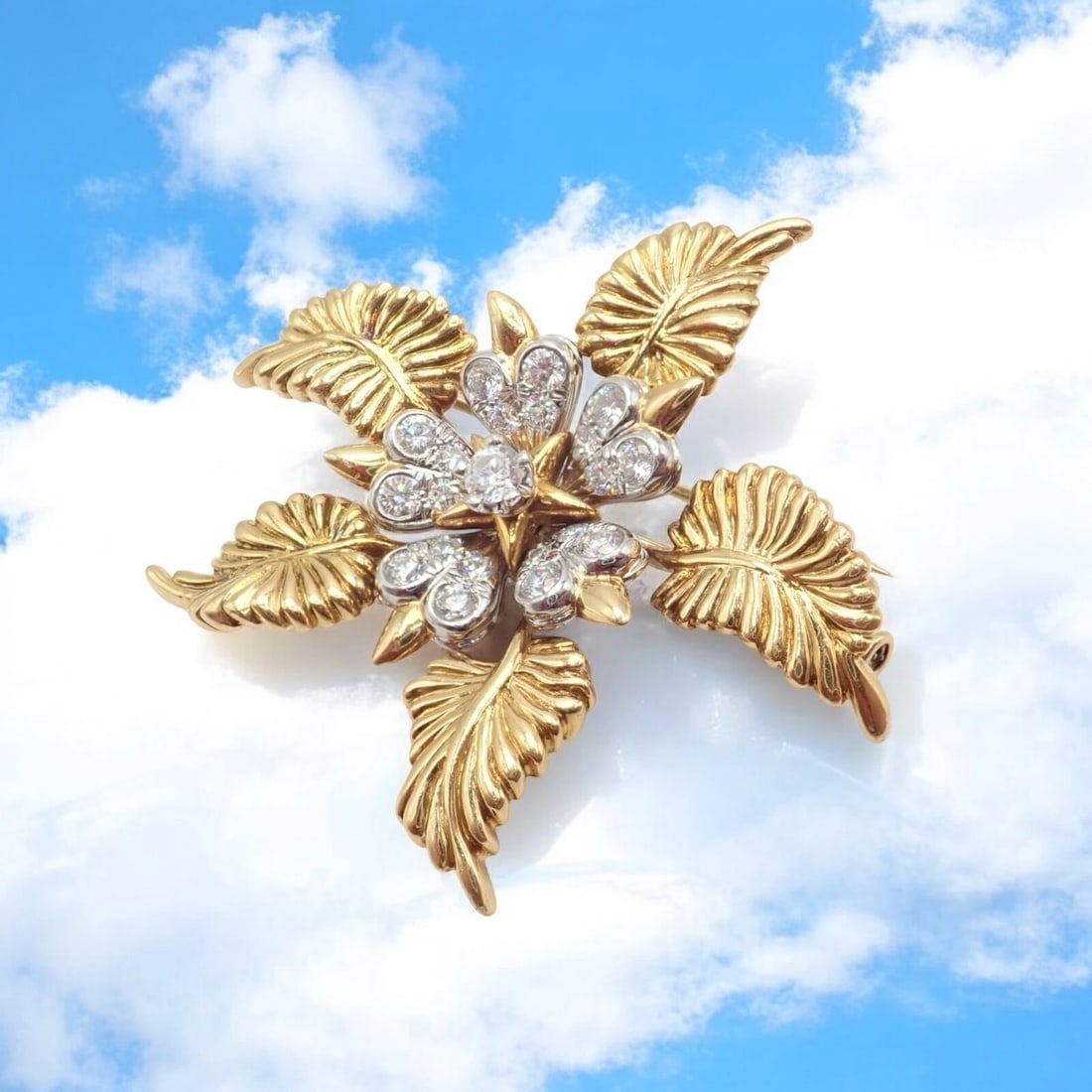Tiffany & Co Schlumberger 18k Yellow Gold Platinum Diamond 5 Leaf Pin Brooch: This stunning Tiffany & Co. Schlumberger 5-leaf pin brooch is crafted in 18k yellow gold and platinum. Featuring five textured leaves and a floral center adorned with brilliant-cut diamonds. It showca
