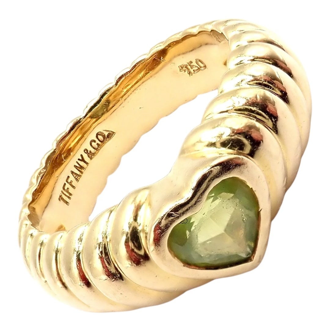 Vintage! Authentic Tiffany & Co 18k Yellow Gold Scalloped Heart Peridot Ring: Vintage Tiffany & Co. 18k yellow gold ring featuring a scalloped, ribbed design and a heart-shaped peridot centerpiece. The warm gold beautifully frames the soft green gemstone, creating a romantic, c