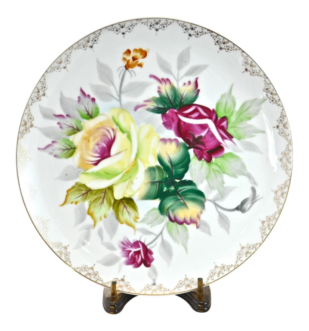 Spring Rose Bouquet Porcelain Plate & Stand: Intricately hand-painted floral porcelain plate with rose flowers in ruby red, deep green, vibrant yellow, and gold gilt. Wood stand included. Tray, 10W x 1H; stand, 4L x 4W x 7.5H. No maker's mark.