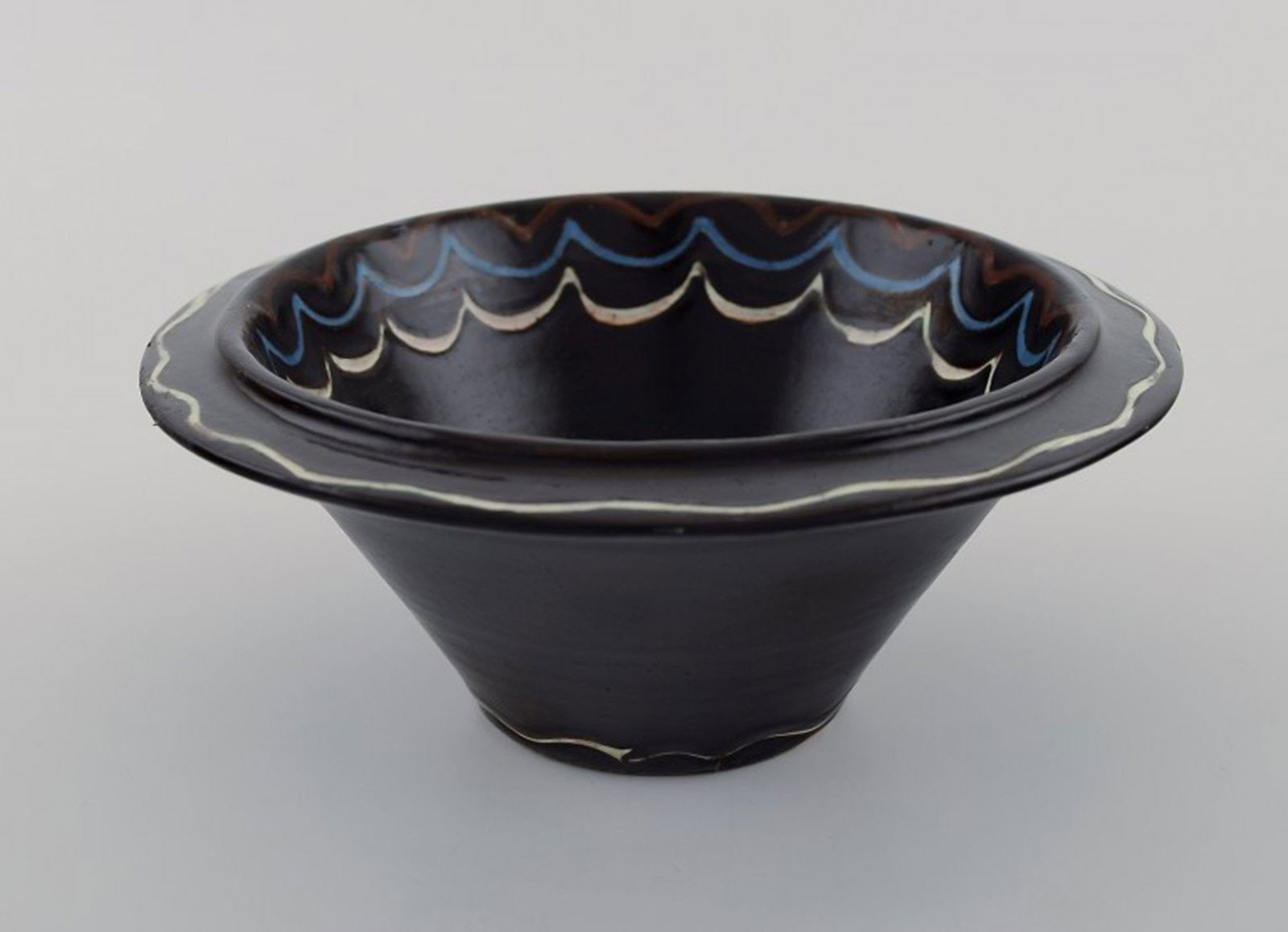 Kähler, Denmark. Bowl in black glazed ceramics with blue and white waves along the edge. 1930s (1 of 5)