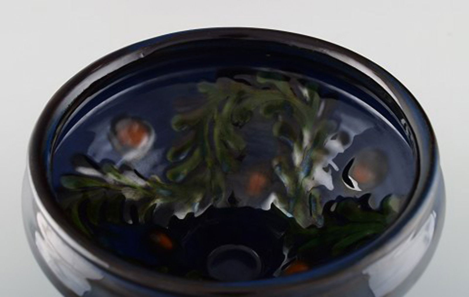 Kähler, Denmark. Bowl in glazed ceramics. Green leaves and red berries on a dark blue - 4