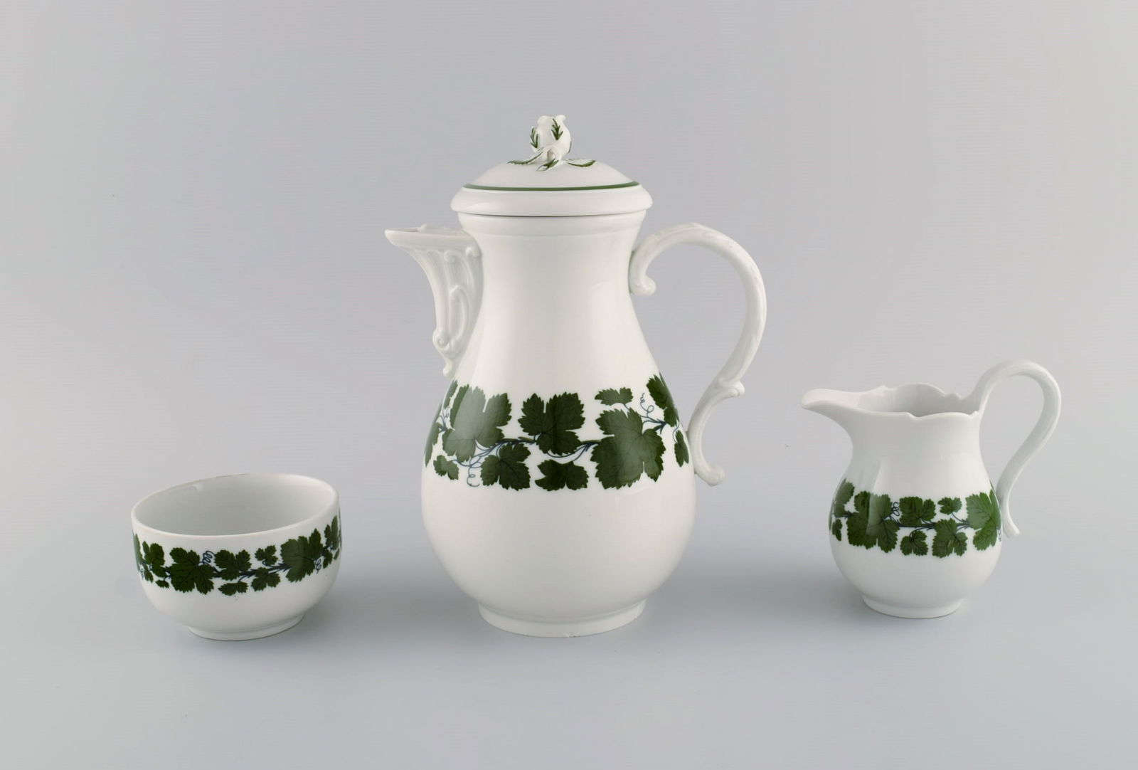 Meissen Green Ivy Vine. Coffee pot, sugar bowl and creamer in hand-painted porcelain. Lid modeled: Title: Meissen Green Ivy Vine. Coffee pot, sugar bowl and creamer in hand-painted porcelain. Lid modeled with rose bud. 1940's. Description: Meissen Green Ivy Vine. Coffee pot, sugar bowl and creamer